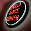 Un vibrante letrero de neón brilla suavemente en una pared tenue, anunciando el Sevilla Dance Center: Academia de baile urbano en el corazón de Sevilla. - ForTwo - Planes para parejas