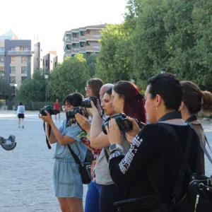 Un grupo captura momentos con "Taller de Fotografía en Granada: aprende a dominar tu cámara réflex", en medio de los árboles y edificios de Granada. - ForTwo - Planes para parejas