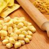 El Taller de Pasta Fresca en Sevilla y un fiel rodillo descansan sobre una superficie de madera, listos para preparar deliciosas comidas. - ForTwo - Planes para parejas