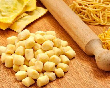 El Taller de Pasta Fresca en Sevilla y un fiel rodillo descansan sobre una superficie de madera, listos para preparar deliciosas comidas. - ForTwo - Planes para parejas