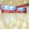 El espacioso estudio de baile, con piso de madera, espejos de pared y murales con temática de baile, es perfecto para practicar Tango o Ritmos Latinos en las "Clases de Baile de Salón en Madrid – Ritmos Latinos, Swing y Tango". - ForTwo - Planes para parejas
