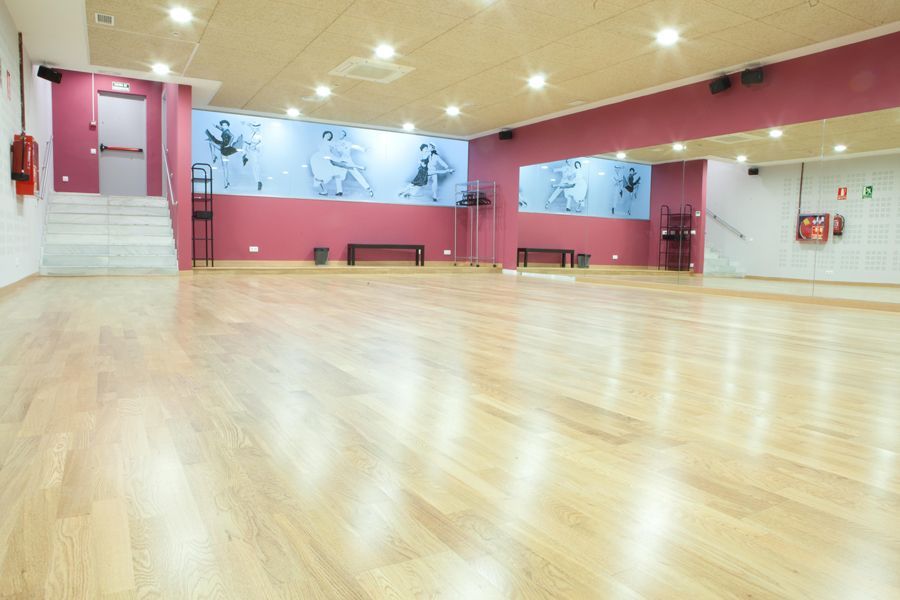 El espacioso estudio de baile, con piso de madera, espejos de pared y murales con temática de baile, es perfecto para practicar Tango o Ritmos Latinos en las "Clases de Baile de Salón en Madrid – Ritmos Latinos, Swing y Tango". - ForTwo - Planes para parejas