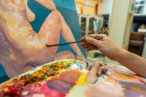 Artistas en Zaragoza asisten a Clases de Dibujo y Pintura en Zaragoza, donde pintan a mano figuras desnudas sobre lienzo, utilizando una paleta vibrante para capturar cada detalle en primer plano. - ForTwo - Planes para parejas