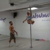 En un estudio de baile en Madrid, alguien cautiva a una audiencia con su fascinante rutina, mostrando el arte del pole dance como parte de Clases de Pole Dance en Madrid. - ForTwo - Planes para parejas