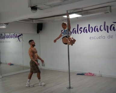 En un estudio de baile en Madrid, alguien cautiva a una audiencia con su fascinante rutina, mostrando el arte del pole dance como parte de Clases de Pole Dance en Madrid. - ForTwo - Planes para parejas