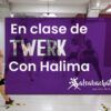 Personas en una clase de baile practicando movimientos de twerk. Texto superpuesto: En clase de TWERK con Halima, Salsabachata escuela de baile. Descubre las Clases de Twerk en Madrid y libera tu ritmo. - ForTwo - Planes para parejas