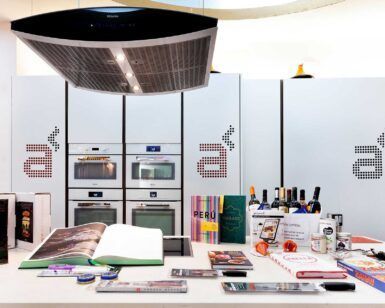 Una cocina moderna en Madrid cuenta con elegantes electrodomésticos con una encimera repleta de libros de cocina y productos gourmet Diviértete Cocinando en Madrid A Punto, perfectos para preparar deliciosos platos combinados con buen vino. - ForTwo - Planes para parejas