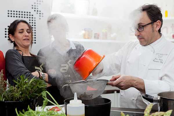 En una vibrante cocina madrileña, un chef usa sus habilidades culinarias y un estilo natural mientras cocina para sorprender a los espectadores en este momento "Divídete Cocinando en Madrid A Punto". El vapor se arremolina al colar la pasta, captando la atención. - ForTwo - Planes para parejas