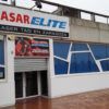 El Laser Tag en Zaragoza con Quasar Elite presenta un exterior deslumbrante con diseños geométricos de ventanas que se reflejan en el suelo mojado, invitando a los amantes de las emociones fuertes a una aventura de laser tag inolvidable. - ForTwo - Planes para parejas