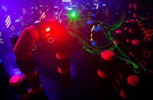 La arena Lasertag en Laserspace Zaragoza - Pack Ocio vibra de emoción, con iluminación tenue y obstáculos de neón que crean un entorno emocionante para una batalla de Lasertag inolvidable. - ForTwo - Planes para parejas