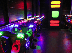 El equipo de Lasertag en Laserspace Zaragoza - Pack Ocio está alineado en el interior de una arena poco iluminada. - ForTwo - Planes para parejas