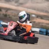 Vestido con mono de carreras y casco, un piloto maniobra con destreza el kart número 5 por la pista en ¡Acelera en el Karting de Mozota en Zaragoza!. - ForTwo - Planes para parejas