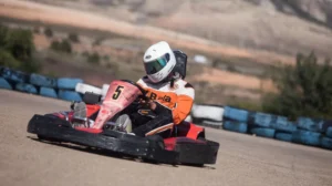 Vestido con mono de carreras y casco, un piloto maniobra con destreza el kart número 5 por la pista en ¡Acelera en el Karting de Mozota en Zaragoza!. - ForTwo - Planes para parejas