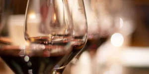 Primer plano de varias copas de vino llenas de Vinos Brabantino: Cata Privada de Sabores Premium, con un fondo borroso y una iluminación suave que realza la experiencia. - ForTwo - Planes para parejas
