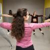 En un animado estudio de paredes grises y amarillas, la gente irradia alegría mientras se estira y se mueve en sus Clases de Salsa en Huesca: Aprende a Bailar con Ritmo y Pasión. - ForTwo - Planes para parejas