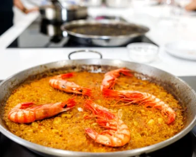 La paella de mariscos con langostinos, cocinada a la perfección, despierta al chef que llevas dentro. Con los sabores de un plato clásico, es como experimentar "¡Cursos de Cocina: ¡Despierta al Chef que Lleva Dentro!" en la comodidad de tu cocina. - ForTwo - Planes para parejas
