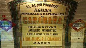 La pared de azulejos de la estación madrileña de Chamberí muestra un anuncio antiguo de aguas minerales de Carabaña, que encarna el encanto del Madrid de los años 20. Esta joya escondida en la Estación Fantasma cuenta historias olvidadas. Descúbrelo en "Descubre la Estación Fantasma de Chamberí: Un Viaje al Madrid de los Años 20. - ForTwo - Planes para parejas