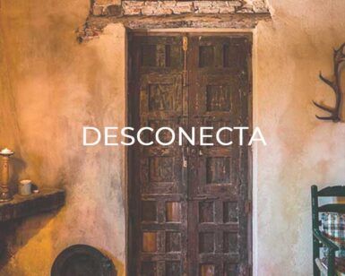 La Escapada "Desconecta": Relax y Bienestar en Córdoba cuenta con una puerta rústica con el texto "Desconecta", tonos cálidos y el encanto cordobés. Astas adornan la pared, mientras que una silla a la derecha invita a la relajación y el bienestar. - ForTwo - Planes para parejas