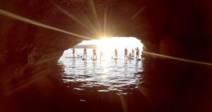 Al ponerse el sol, la gente disfruta de la magia de una tarde ibicenca con "Excursiones de SUP en Ibiza: Atardecer sobre el agua", remando por cuevas y capturando siluetas escénicas. - ForTwo - Planes para parejas