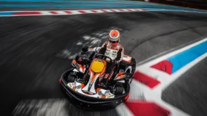 Una persona disfruta de la emoción del Karting en Tenerife Sur (Los Cristianos) en una pista de carreras adornada con líneas y curvas coloridas. - ForTwo - Planes para parejas