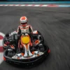 Vestido con ropa de carreras, una persona maniobra hábilmente un kart en la pista de Karting en Tenerife Sur (Los Cristianos), deslizándose rápidamente por los bordillos rojos y blancos. - ForTwo - Planes para parejas