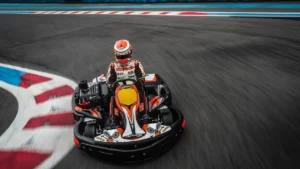 Vestido con ropa de carreras, una persona maniobra hábilmente un kart en la pista de Karting en Tenerife Sur (Los Cristianos), deslizándose rápidamente por los bordillos rojos y blancos. - ForTwo - Planes para parejas