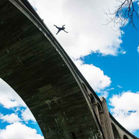 Alguien está viviendo "Puenting en Huesca: Vive la Caída Libre en Murillo de Gállego" desde un puente alto, con un cielo azul y nubes dispersas como telón de fondo. - ForTwo - Planes para parejas