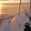Experimenta Puesta de Sol en Catamarán en Ibiza: La Mejor Experiencia Todo Incluido, mientras navegas por un mar tranquilo con el cielo dorado y el sol reflejándose maravillosamente en el agua. - ForTwo - Planes para parejas