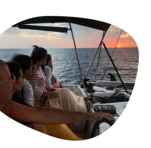 A bordo de la "Puesta de Sol en Catamarán en Ibiza: La Mejor Experiencia Todo Incluido", los juerguistas observan cómo el catamarán navega suavemente, ofreciendo impresionantes vistas del atardecer de Ibiza con vibrantes cielos anaranjados y rosados. - ForTwo - Planes para parejas