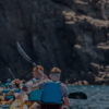 Los kayakistas con chalecos azules disfrutan de una soleada aventura de safari, remando cerca de acantilados rocosos en el "Safari en Kayak y Snorkel en Tenerife". - ForTwo - Planes para parejas