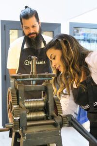 En un pintoresco taller barcelonés, dos artesanos manejan con destreza una vieja imprenta, con los delantales manchados de tinta. Están tan concentrados en su oficio como los joyeros del Taller de Alianzas para Parejas en Barcelona: Crea tus Anillos a Mano. - ForTwo - Planes para parejas