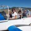 Una familia de cuatro personas disfruta de su vuelo en Avioneta sobre el Parque de Ordesa, sonriendo y saludando dentro de una pequeña avioneta en un día soleado con las pintorescas colinas del parque de fondo. - ForTwo - Planes para parejas