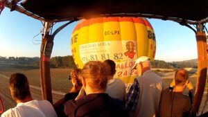 Durante el amanecer sobre el sereno paisaje de Mallorca, personas en un globo aerostático observan a otro cercano, disfrutando de un inolvidable Vuelo en Globo en Mallorca desde Manacor. - ForTwo - Planes para parejas