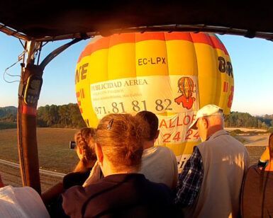 Durante el amanecer sobre el sereno paisaje de Mallorca, personas en un globo aerostático observan a otro cercano, disfrutando de un inolvidable Vuelo en Globo en Mallorca desde Manacor. - ForTwo - Planes para parejas