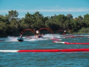 En las vibrantes aguas de Sanxenxo, AcuaKart en Sanxenxo: Carreras de motos de agua ofrece emocionantes carreras en moto acuática a través de arcos rojos en un circuito en zigzag. Los árboles se alzan como telón de fondo bajo un cielo azul despejado, realzando la emoción de navegar por este emocionante entorno. - ForTwo - Planes para parejas