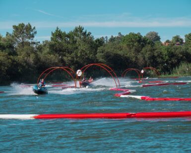 En las vibrantes aguas de Sanxenxo, AcuaKart en Sanxenxo: Carreras de motos de agua ofrece emocionantes carreras en moto acuática a través de arcos rojos en un circuito en zigzag. Los árboles se alzan como telón de fondo bajo un cielo azul despejado, realzando la emoción de navegar por este emocionante entorno. - ForTwo - Planes para parejas