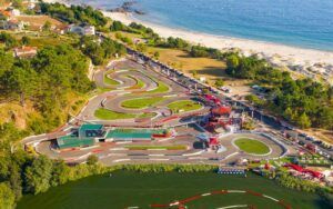 Vista aérea del circuito de motos acuáticas AcuaKart en Sanxenxo junto al mar, bordeado de árboles y edificios. - ForTwo - Planes para parejas