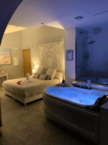 El Hotel con encanto en el centro de Badajoz ofrece un acogedor dormitorio con jacuzzi iluminado, elegante cama, decoración romántica con toallas de cisne y una iluminación tenue, proporcionando una escapada encantadora con lujo y encanto en el corazón de Badajoz. - ForTwo - Planes para parejas