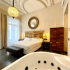 Disfrute de un elegante dormitorio con una cama grande, un espejo ornamentado, una lámpara de araña y un jacuzzi en la habitación en el Hotel con encanto en el centro de Badajoz, una mezcla perfecta de encanto y lujo. - ForTwo - Planes para parejas