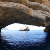 Experimente la impresionante belleza de un arco de piedra natural sobre tranquilas aguas azules, enmarcando una isla rocosa distante en su Aventura en lancha: Playas y cuevas de Ibiza, explorando impresionantes playas de Ibiza y joyas ocultas como cautivadoras cuevas. - ForTwo - Planes para parejas