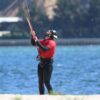 En una playa de arena de Pontevedra, alguien con una camiseta roja disfruta de su primera clase de kitesurf, bautismo de kitesurf en Pontevedra, mientras maniobra una cometa con el inmenso océano como telón de fondo. - ForTwo - Planes para parejas