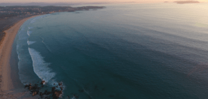 Puesta de sol sobre la tranquila costa de O Grove con suaves olas y un horizonte lejano, realzado por las Clases de Paddle Surf en O Grove añadiendo un toque aventurero. - ForTwo - Planes para parejas