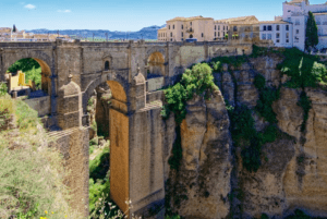 La "Excursión a Ronda y Setenil desde Málaga" te permite explorar el majestuoso puente de piedra que cruza un profundo desfiladero, con edificios sobre acantilados rocosos rodeados de exuberante vegetación, ofreciendo una mezcla de belleza natural y encanto histórico para una aventura inolvidable. - ForTwo - Planes para parejas