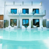 Esta moderna villa blanca, con amplios ventanales y balcones, ofrece vistas a una piscina cristalina y un remanso de paz. Combinando lujo y relajación bajo un cielo azul despejado, evoca la esencia de PAIISE Hotels Ibiza: Relájate cerca de las playas. - ForTwo - Planes para parejas