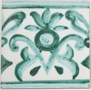 El azulejo Pinta Tu Propio en Triana presenta un patrón floral y de remolinos verdes sobre una baldosa de cerámica blanca, que hace eco del arte tradicional de Triana. - ForTwo - Planes para parejas