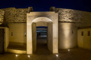 La entrada en arco de piedra de la histórica fortaleza iluminada por la noche ofrece una mirada cautivadora a la historia, similar al "Tour por las murallas de Badajoz y Elvas" en una noche iluminada por la luna. - ForTwo - Planes para parejas