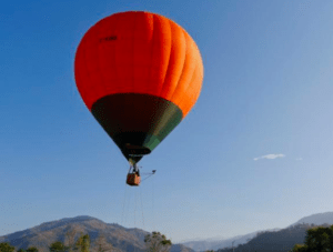 Al amanecer, el Vuelo en Globo en Badajoz al amanecer se desliza grácilmente sobre el paisaje, revelando majestuosas montañas y un cielo azul claro. - ForTwo - Planes para parejas