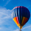 El "Vuelo en Globo en Badajoz al amanecer" ofrece una experiencia impresionante mientras un vibrante globo aerostático se desliza elegantemente contra el cielo azul brillante, ofreciendo vistas impresionantes de Badajoz. - ForTwo - Planes para parejas
