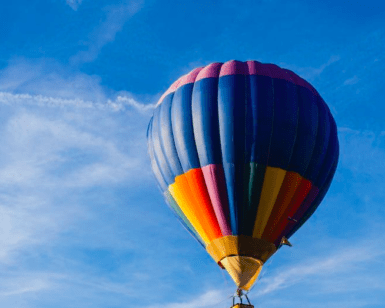 El "Vuelo en Globo en Badajoz al amanecer" ofrece una experiencia impresionante mientras un vibrante globo aerostático se desliza elegantemente contra el cielo azul brillante, ofreciendo vistas impresionantes de Badajoz. - ForTwo - Planes para parejas