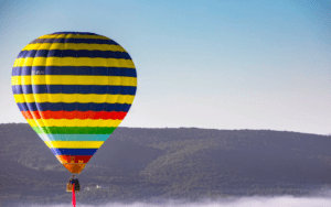 El Vuelo en Globo en Badajoz al amanecer ofrece un vibrante viaje en globo aerostático sobre un paisaje brumoso, con colinas onduladas y cielos azules claros como telón de fondo perfecto. - ForTwo - Planes para parejas